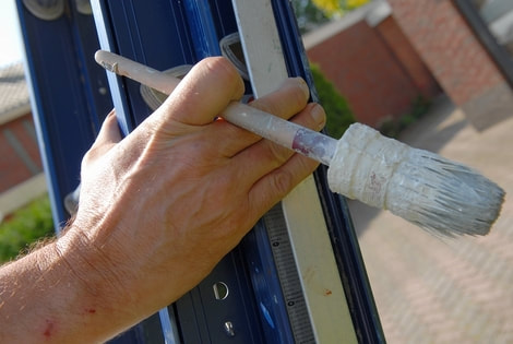 Exterior painters and decorators Swansea climbing ladder with brush in hand